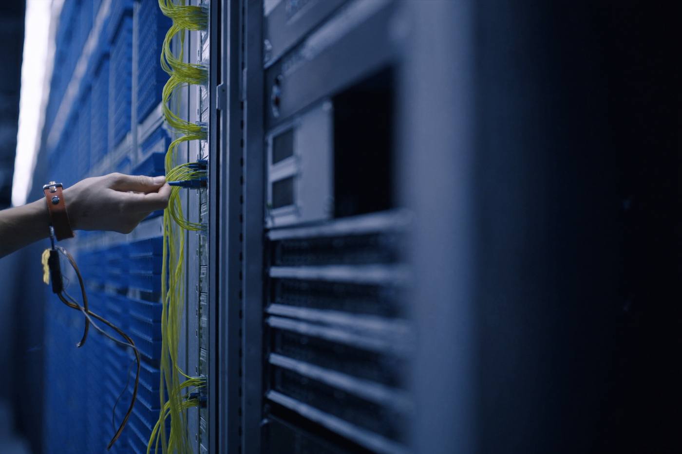 Engineer connecting fibre in a rack
